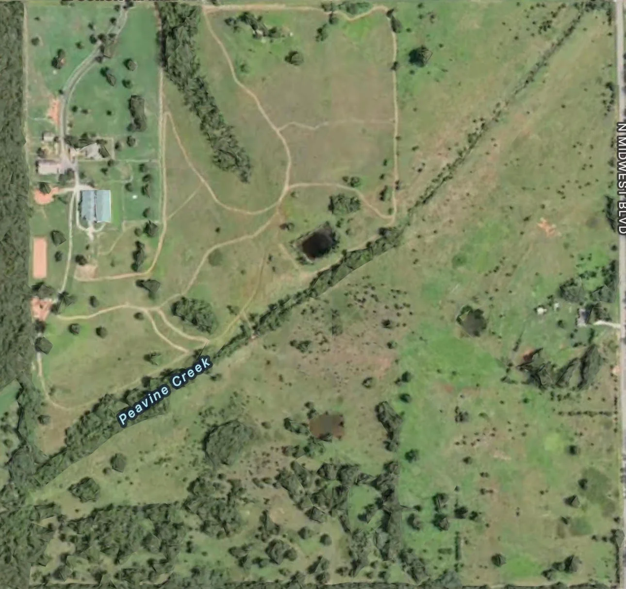 Aerial view of excavated pond and cleared land with Peavine Creek running through property